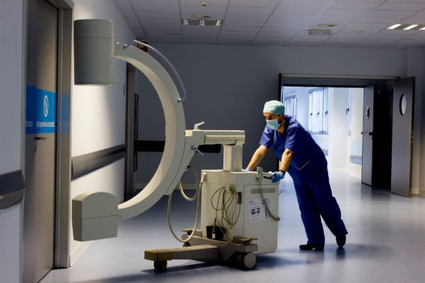 Un profesional desplaza equipamiento sanitario en un centro hospitalario para ilustrar el concepto de logística hospiatalaria eficaz